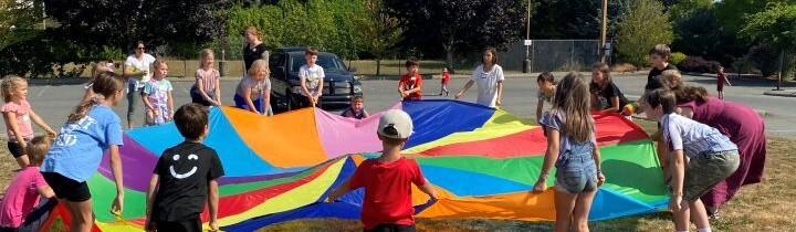 Children outside playing with colourful parachute